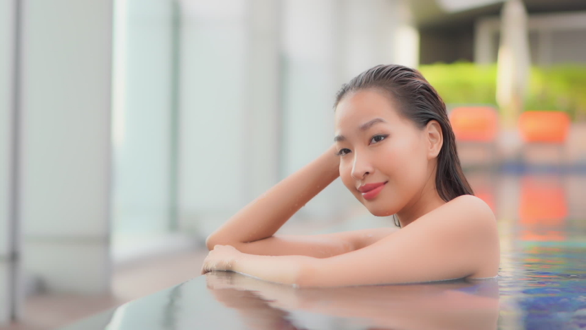 Gorgeous Asian Woman Standing In Swimming Pool Medium Shot Slow Motion | Shutterstock HD Video #1061706688
