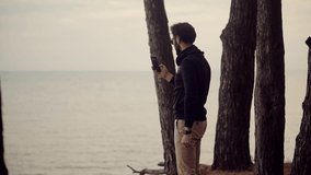 Man Holding Mobile Phone Using Mobile App And Taking Picture.Male Relaxing On Nature.Man Takes Photo On Smartphone Camera On Beach.Handsome Guy Enjoying View On Holiday Vacation Adventure Trip On Sea.
