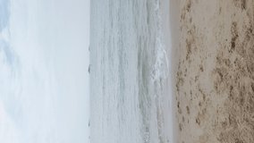 Vertical Video: Asian couple in love running jump celebrating success with raised arms into the air on the holiday weekend. Romantic couple on the beach vacation travel.