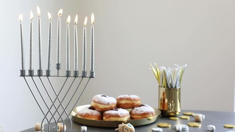 Hanukkah table with doughnuts and silver and gold decorations