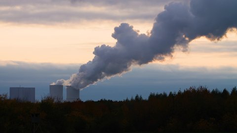Time lapse of a coal power plant in Germany during sunset. Wide shot of a power plant that is under criticism for air pollution and the greenhouse gasses it emits that contribute to global warming.