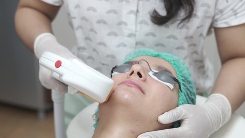 Young woman getting face laser hair removal epilation. IPL treatment in cosmetic beauty salon