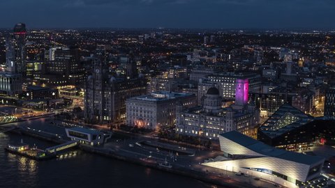 Establishing Aerial View of Liverpool UK, at night evening, beautifully lit City Waterfront, United Kingdom