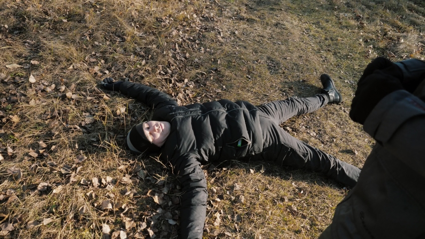 Man in a hat giving first aid to his friend