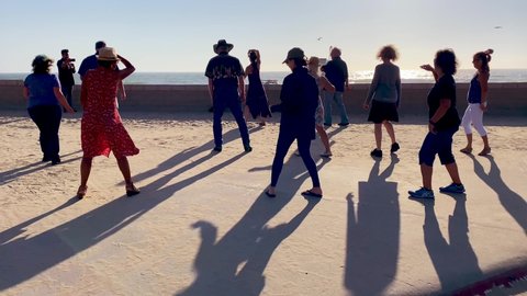 SOUTHERN CALIFORNIA - CIRCA 2020 - People practice learn line dancing and dance outdoors at a beach in Ventura, Southern California.