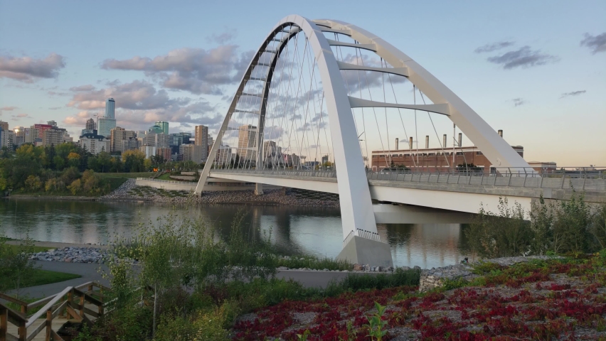 Walter Dale Modern Bridge bowstring designed by a Korean in Edmonton Alberta Canada. Side view where no people are walking by, vehicles headed downtown to the city core on an early evening. | Shutterstock HD Video #1061734390