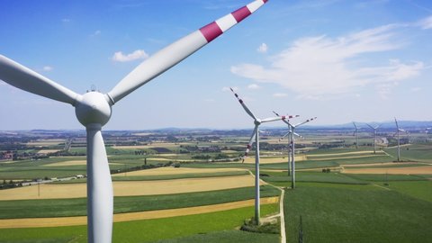 Aerial flight near wind turbines. Clear renewable energy production. Farm landscape. Sky drone footage 4k