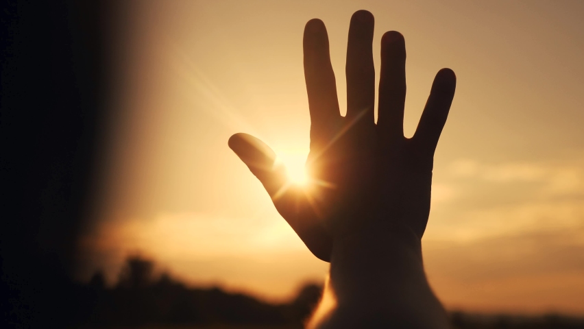 Girl stretches out her hand in the sun. faith in god dream religion concept. hand in the sun close-up silhouette dream of happiness sunlight | Shutterstock HD Video #1061747530