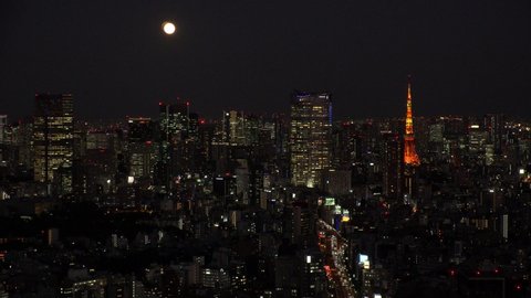 TOKYO, JAPAN - NOVEMBER 2019 : Aerial high angle view of cityscape of TOKYO at night. Scenery of central downtown area and business district. Full moon in the sky. View from Shibuya ward.