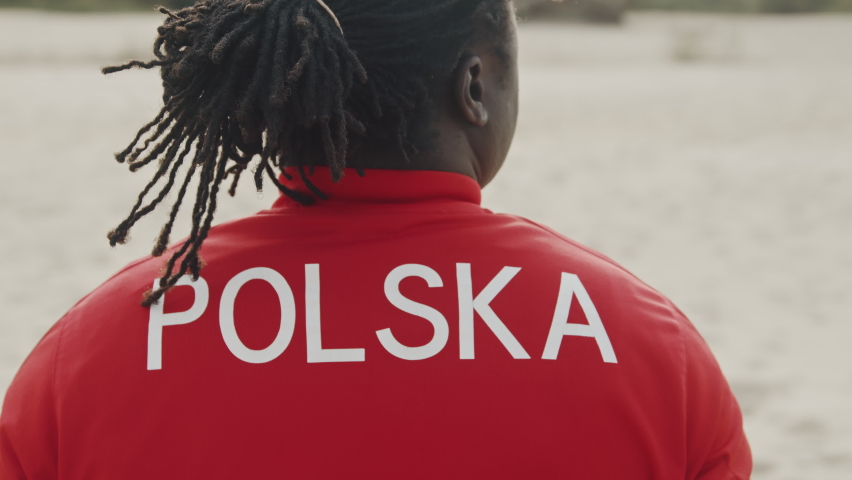 Back view of african american black man in red shirt. Poland writen on the back
