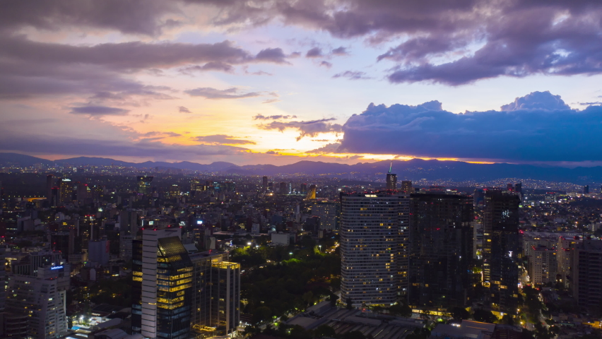Aerial hyperlapse over Mexico city with house and office buildings in the foreground and a beautiful sunset in orange tones Royalty-Free Stock Footage #1061756629