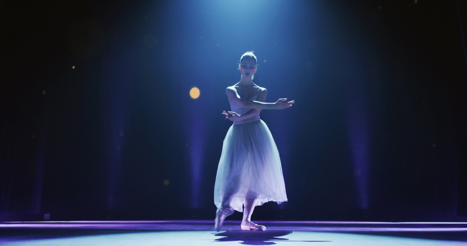 Cinematic, Special Effect Editted Shot of Young Graceful Ballerina Dancing on a Theatre Stage Under a Spotlight. Female Ballet Dancer Performing a Choreography Magically, Living her Dream  Royalty-Free Stock Footage #1061760847