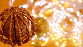 Golden Christmas bokeh of light and twinkling garlands, Christmas ball spinning. background video of the winter holiday