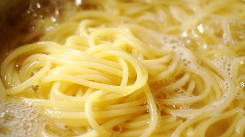 Close-up of spaghetti pasta In boiling hot water in steel pan. preparation for making pasta