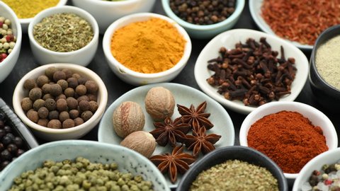 Assortment of aromatic spices and herbs in smal bowls rotating