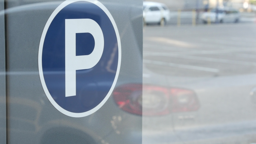 Parking lot sign as symbol of traffic difficulties and transportation issues in busy urban areas of USA. Public paid parking zone in downtown of San Diego, California. Limited space for cars in city.