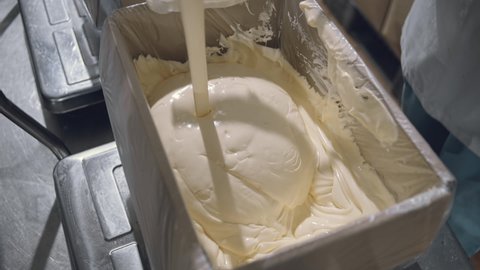 Liquid Butter. Vanilla Ice Cream Pouring into a Huge Box, Ladle, Container in the Plant of Milk Production. Tasty, Sweet, Appetizing Product, Food, Dessert  Manufacture, Close Up