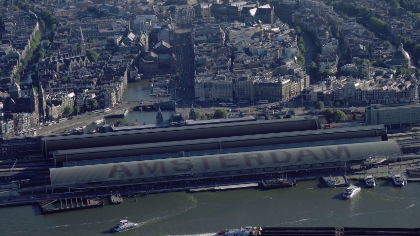
Aerial view of the famous Amsterdam Centraal Station, the largest railway station in Netherlands. Many ferries in the IJ. 