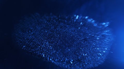In the dark with blue illumination on a smooth surface, a distinct fingerprint of the alleged killer was found. Crime scene investigation. Shooting allows you to see the smallest details of the print 