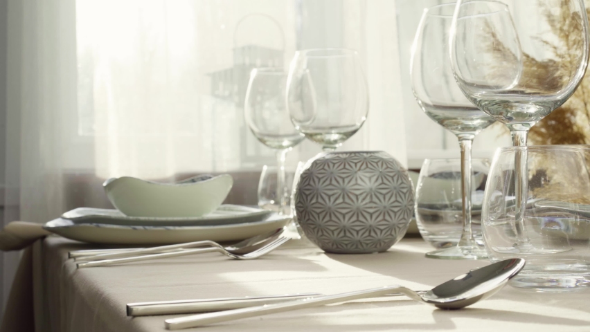 Close up of woman setting table. Housewife or waitress hands putting plates on dining table