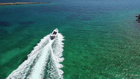 Aerial drone tracking video of inflatable rib speed boat cruising at high speed in the deep blue Aegean sea.