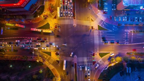 night time illuminated qingdao city famous downtown traffic street crossroad aerial topdown timelapse 4k china