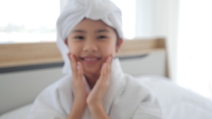 Asian cute little girl rest beauty care wearing towels look at camera at home, skincare kid beauty and glamour. Smiling asian girl wearing bathrobe and towel after shower.