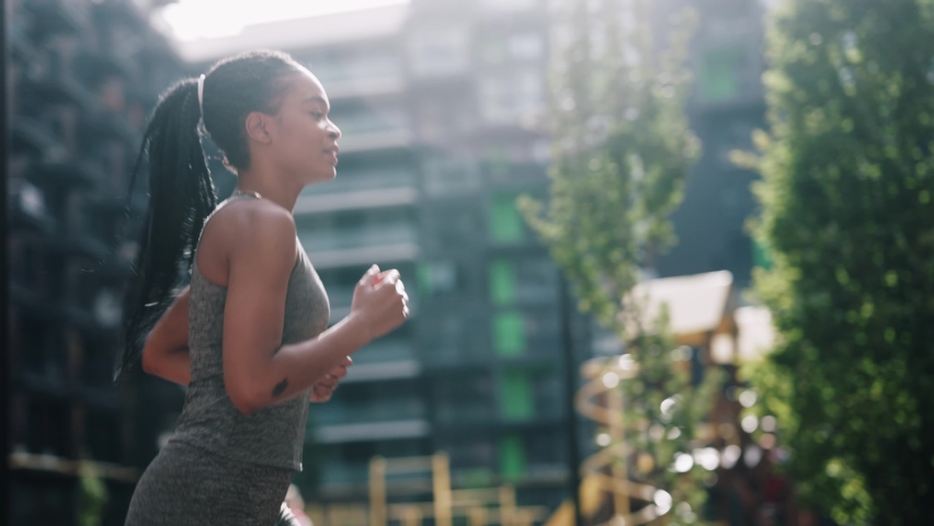 African american active fitness woman runner jogging in sunny street summer day outdoors. Jogger activity. Female athlete. Sportswoman. Cardio exercises. Workout concept. Royalty-Free Stock Footage #1061781952