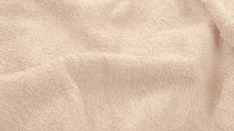 Towel texture closeup. Soft beige color cotton towel backdrop, fabric background. Terry cloth bath or beach towels. Macro. 4K UHD video, slow motion. 