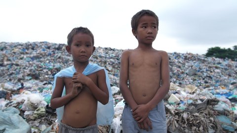 Poor Children Standing With Garbage Dump
