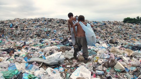 Poor Children Walking On Garbage Dump
