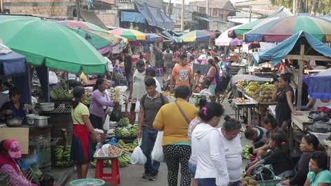 Lima, Peru – April 15, 2019. peru market. many people walk between the rows with meat and bananas and fruits. eating street food. sellers in the market. shoppers came to buy groceries on the street 