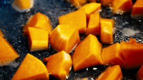 Cooking pumpkin soup. Frying cubed pumpkins. Healthy food, diet. Homemade meal with autumn pumpkin. Preparing traditional pumpkin soup