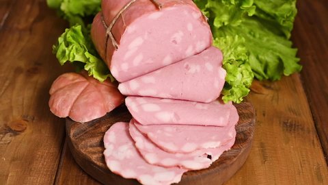  Traditional big sausage and black pepper pistachios Region Emilia Romagna and the city of Bologna. Italian Whole block of mortadella on a wooden plate. Top view. 