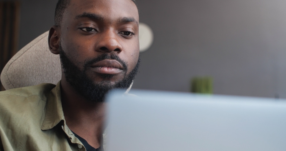 Close Up Portrait of Handsome African American Freelancer is working concentrated on Laptop. Contemporary Casual Male is working distantly, having Online Job. Technology. People. Freelance. Royalty-Free Stock Footage #1061817301