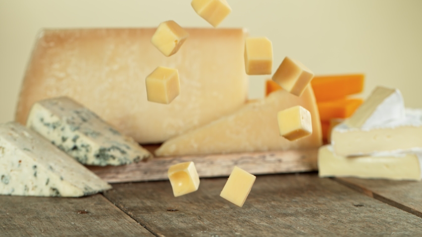 Super Slow Motion Shot of Cheese Cubas Falling on Wooden Board at 1000 fps. | Shutterstock HD Video #1061819251