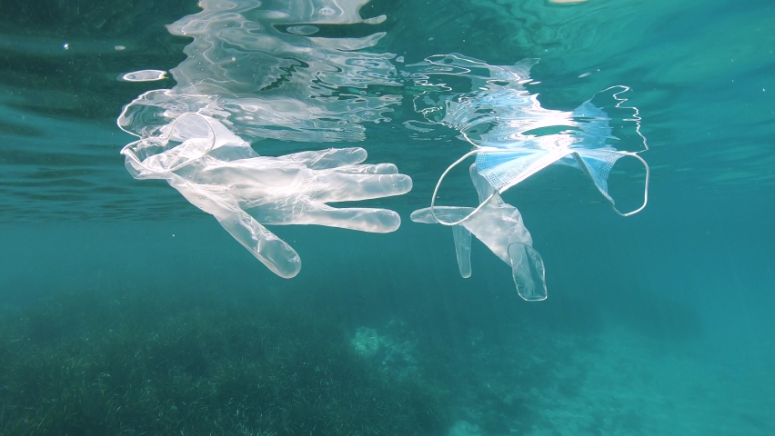 Face mask and gloves float under water surface in the sea, plastic waste pollution since coronavirus COVID-19 pandemic, Mediterranean sea, France Royalty-Free Stock Footage #1061820520