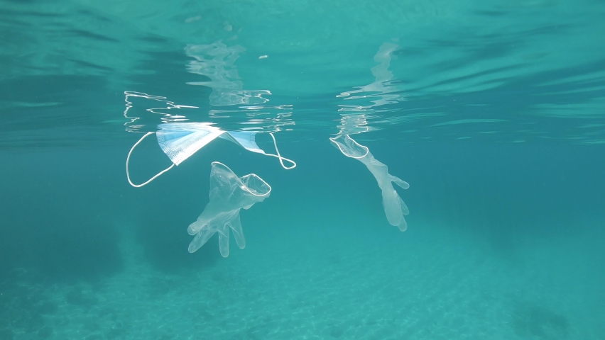Face mask and gloves under water surface in the ocean, plastic waste pollution since coronavirus COVID-19 pandemic Royalty-Free Stock Footage #1061820523