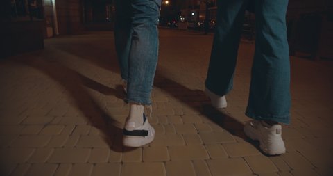 Male and female feet walking on the street, couple of modern hipsters in city