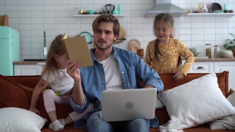 Caucasian male working from home with children, checking documents.