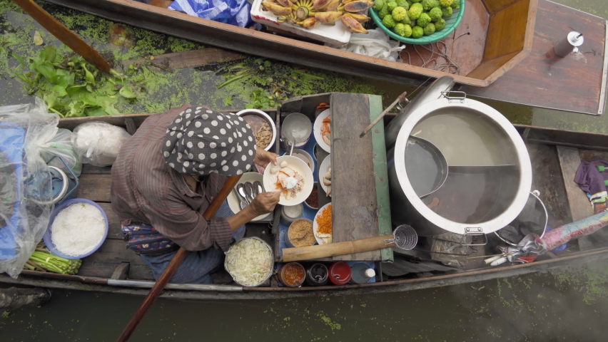 Damnoen Saduak Floating Market or Amphawa. Local people sell fruits, traditional food on boats in canal, Ratchaburi District, Thailand. Famous Asian tourist attraction.