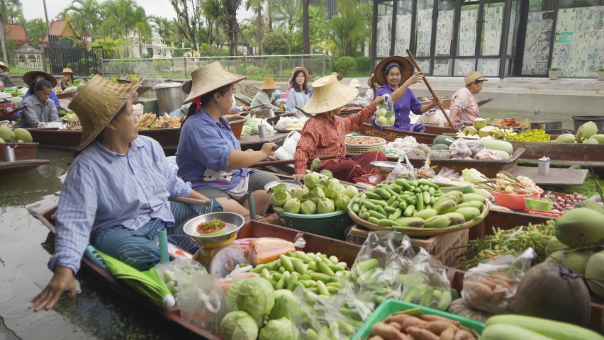 Damnoen Saduak Floating Market or Amphawa. Local people sell fruits, traditional food on boats in canal, Ratchaburi District, Thailand. Famous Asian tourist attraction.