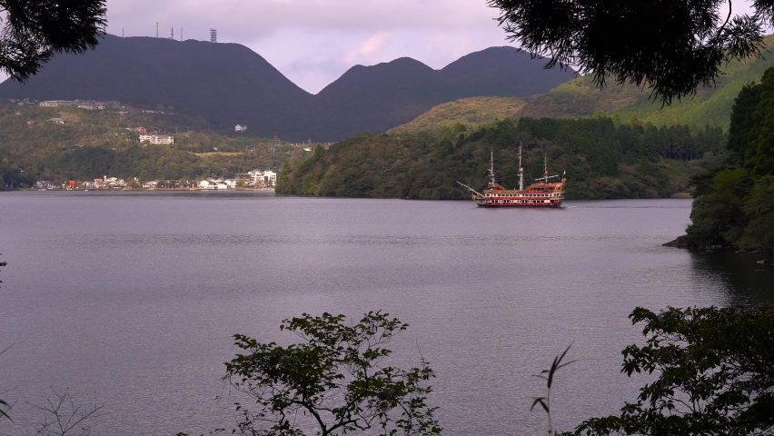 View out on famous Hakone pirate ship on Lake Ashi framed by silhouettes trees