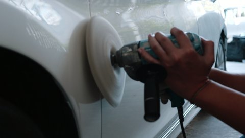 White car body polishing with polisher tool in auto service. Waxing car after car wash. Car body work - 4K