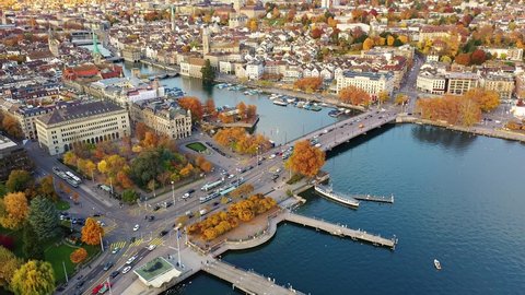 Aerial footage of the Zurich old town where the Limmat river joins lake Zurich with tramway running on a bridge in Switzerland largest city. 