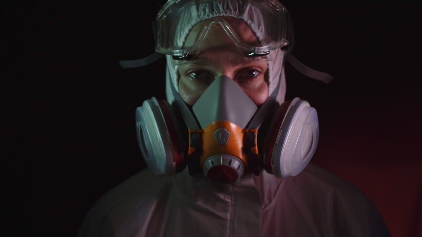 Man in protective costume suit, gas protect medical antibacterial antiviral spray paint mask. Doctor health worker in respirator. Concept health virus coronavirus epidemic. Radiation Nuclear war. | Shutterstock HD Video #1061835991