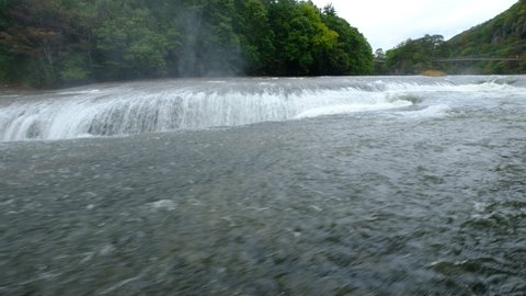 A 4K panoramic wide & low angle shot of water stream that flows noisily in a huge rocky environment at Fukiware Falls (often called "Japan's version of Niagara Falls"), near Nikko, Japan.