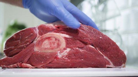 The Butcher Cuts the Fresh Beef Meat into Portions Using a Sharped Butcher Knife