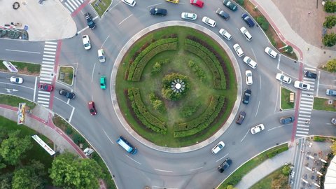 Vehicles on a busy roundabout junction. Traffic circle with a lot of cars. Top down aerial view on a circular intersection in Podgorica Montenegro.