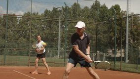 Healthy senior man and woman playing tennis on outdoor tennis court and win. They give each other hands and smile. Sport and active lifestyle theme. - Powered by Shutterstock - Get 15% off with code: PIKWIZARD15
